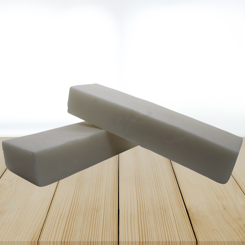 Goat milk soap base blocks on a wooden surface with a white background